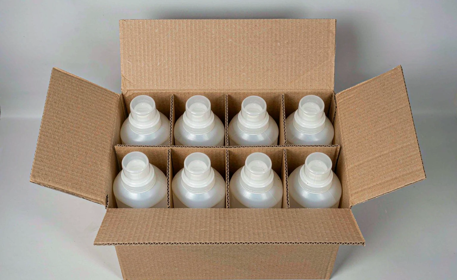 A corrugated carton with household cleaning bottles inside, flaps open